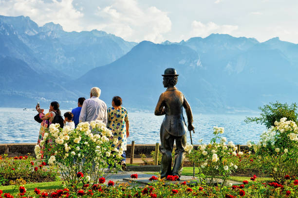 menschen bei charlie chaplin-statue am genfer see von vevey - seepromenade stock-fotos und bilder