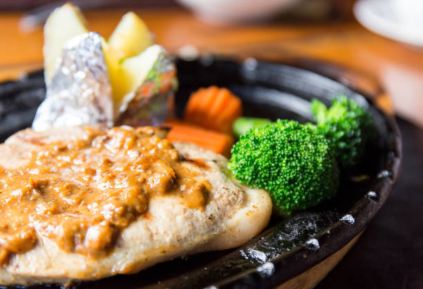 delicious pork chop steak with potato and vegetable on hot pan