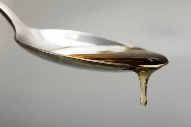 istock Honey pouring from spoon against a light background 665545116