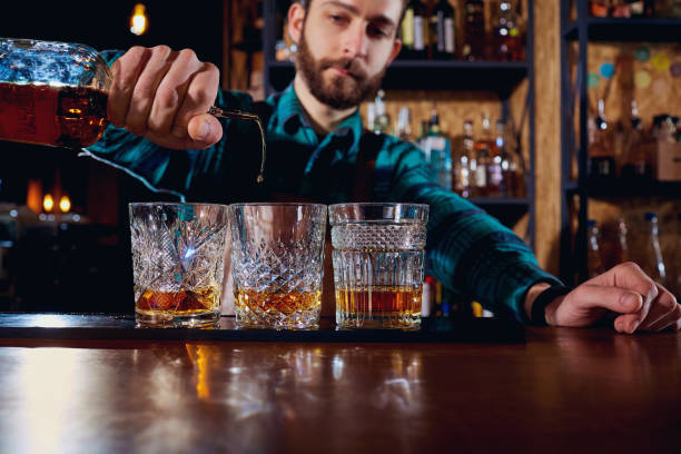 das barkeeper gießt alkohol in einem glas. close-up - alcoholism assistance photography people stock-fotos und bilder