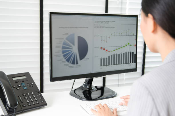 istock Close up business woman working in office with business graph on computer 665548948