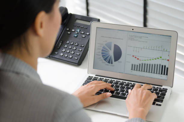 istock Close up business woman working in office with business graph on computer 665548952