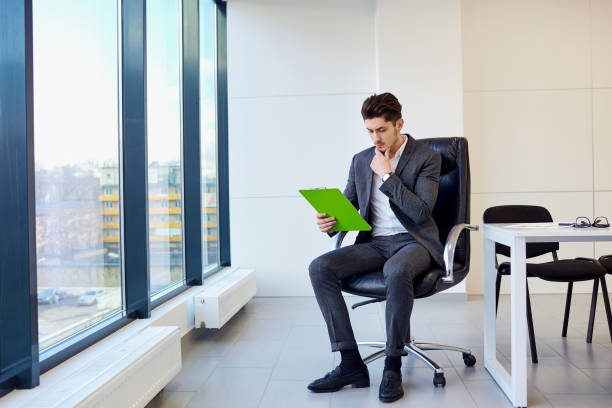 istock Businessman with pen in hand reading, thinking over contract pap 665549288