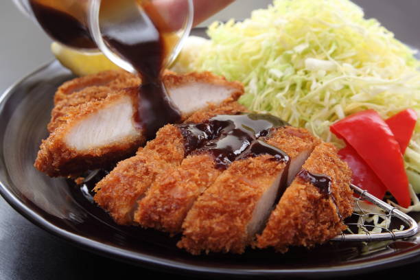 frittierte schweineschnitzel mit salat und zitrone, japanische lebensmittel - tonkatsu stock-fotos und bilder