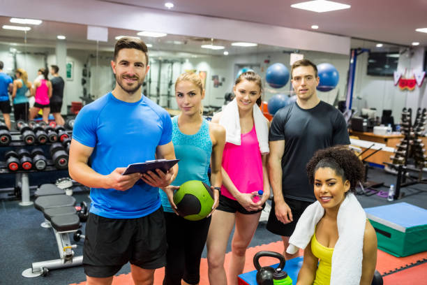 istock Fit people smiling at camera in weights room 665561348