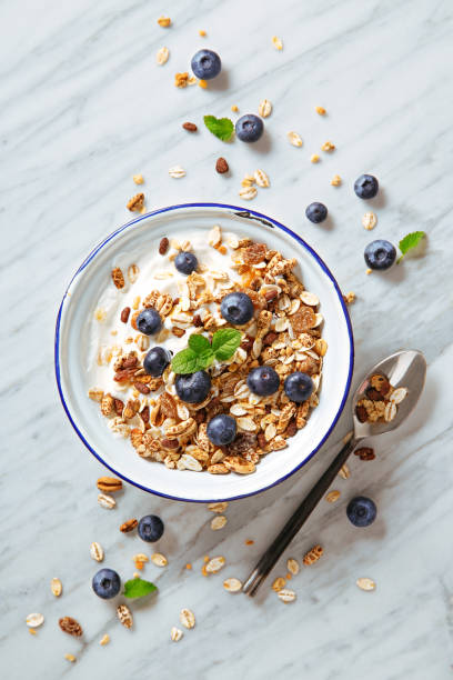Cereals breakfast with blueberries on a marble background. Healthy morning meal with fresh berries. Top view stock photo