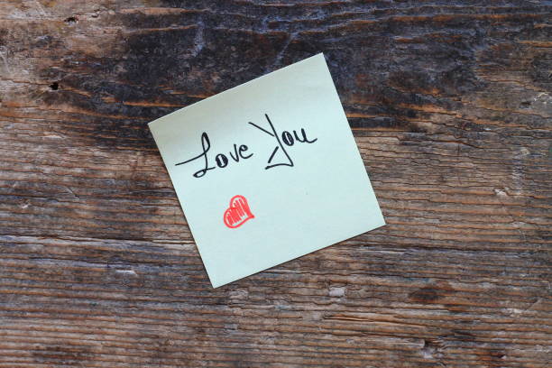 istock Message Love You with small red heart on wooden table 665570154