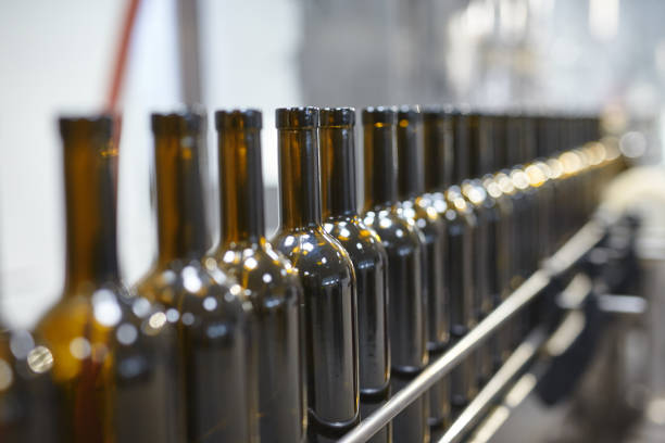 istock Row of glass wine bottles moving by conveyor 665580966