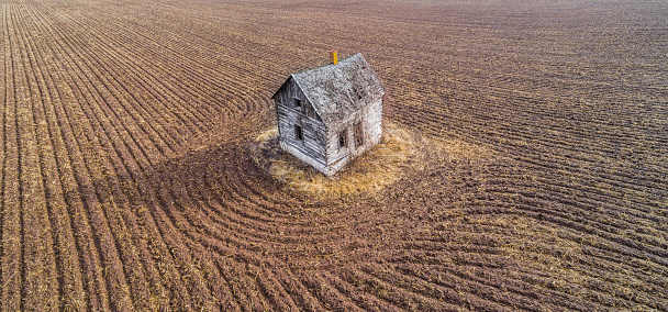 Little, abandoned, old house on an island in time. It sits isolated, in a vast farm field, remembering the loving family who built it, lived there for generations, then left it all alone.