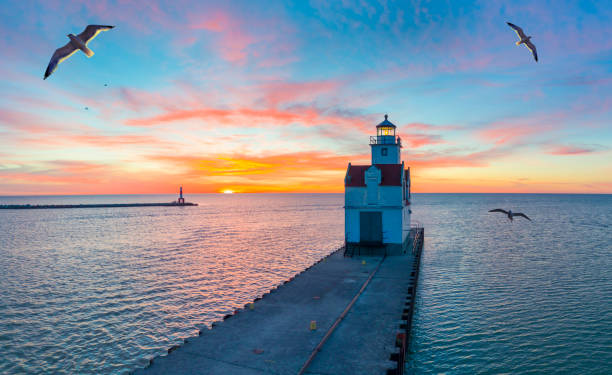 Sunrise over Lake Michigan scenic harbor and lighthouse Sunrise over Lake Michigan scenic harbor and lighthouse with seagulls. great lakes stock pictures, royalty-free photos & images