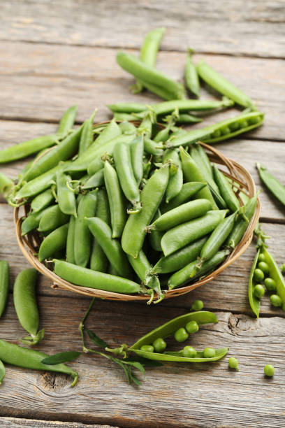 istock Green peas on a grey wooden table 665586100