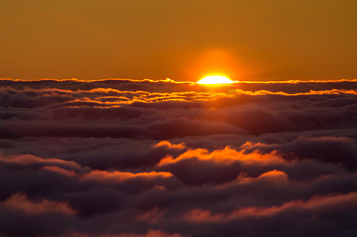 Spectacular view of a sunset above the clouds from the top of the mountain