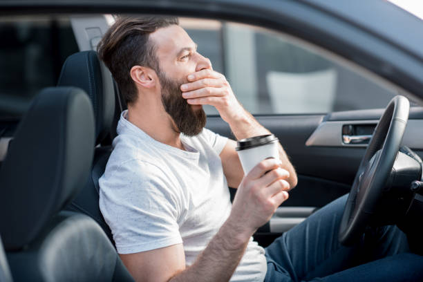uomo stanco alla guida di un'auto - yawning women drink coffee cup foto e immagini stock