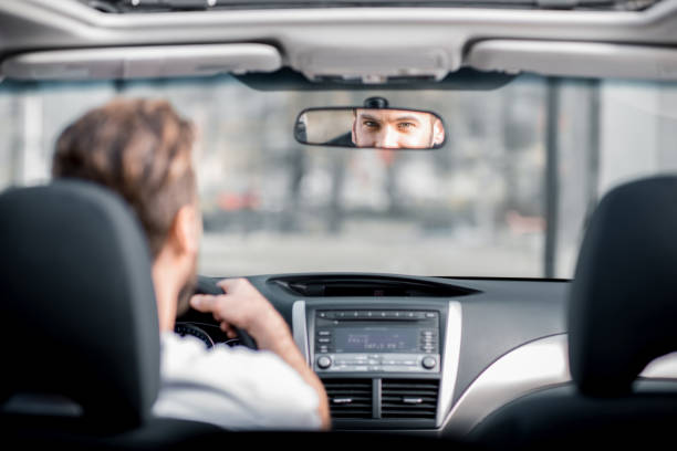 mann, der ein auto fährt - rear view mirror car mirror rear view stock-fotos und bilder