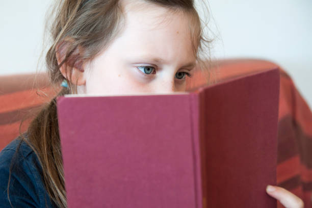 istock Girl sitting on couch and reading a book. 665606906