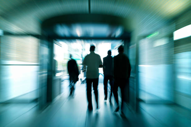 istock Silhouettes of walking people in subway corridor 665607126