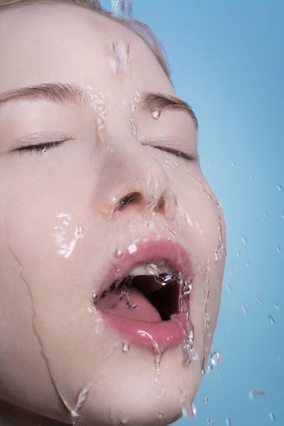 istock Portrait of a blonde close-up on whose face water is pouring. 665609238