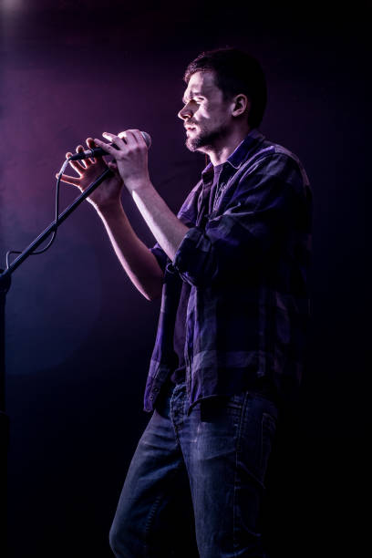 istock man with microphone on a black background, the music concept, beautiful lighting on the stage 665623612