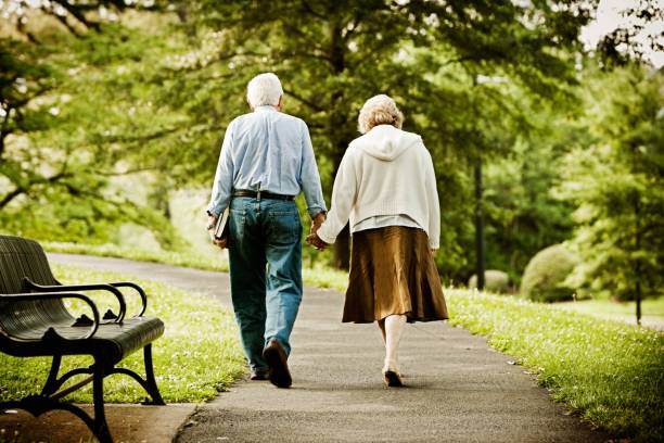 istock Senior Couple Walking in Park 665623644