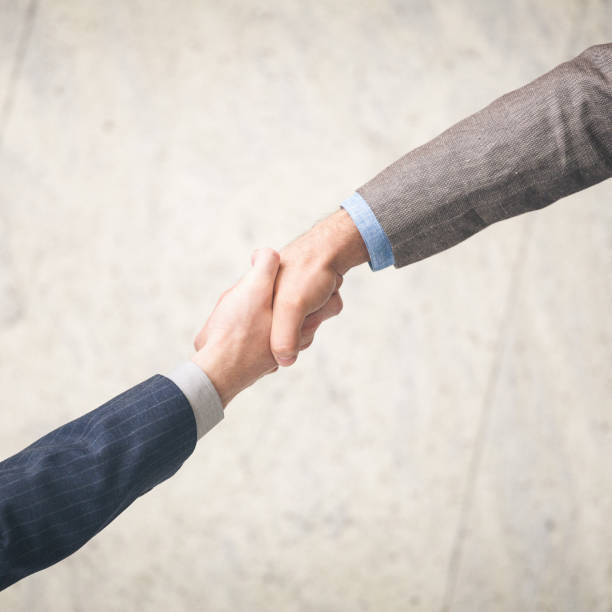 istock Two businessman hand shake overhead shot 665623858