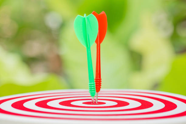 istock target dart with arrow with blur green nature background. 665626378