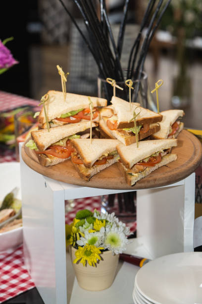 istock Fresh club sandwiches triangular form with tomato on a round wooden chopping board on a table in a expencive restaurant 665626982
