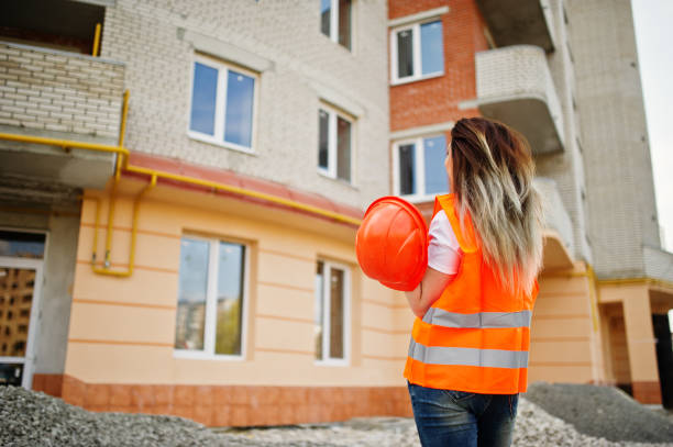istock Engineer builder woman in uniform waistcoat and orange protective helmet 665629988