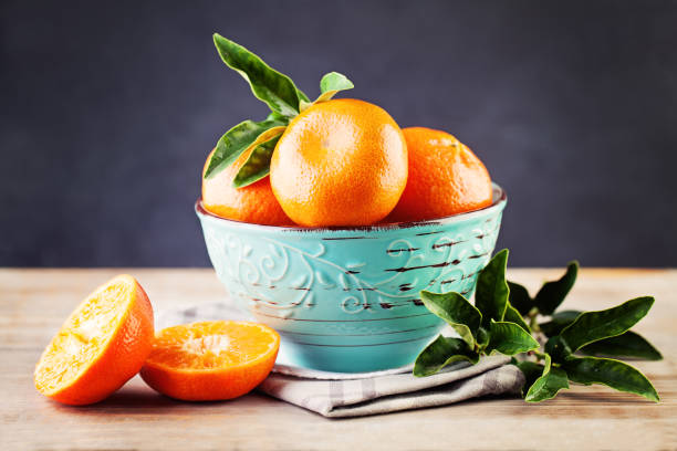 istock Mandarin Fruit with Green Leaves on BlackBoard Background 665630276