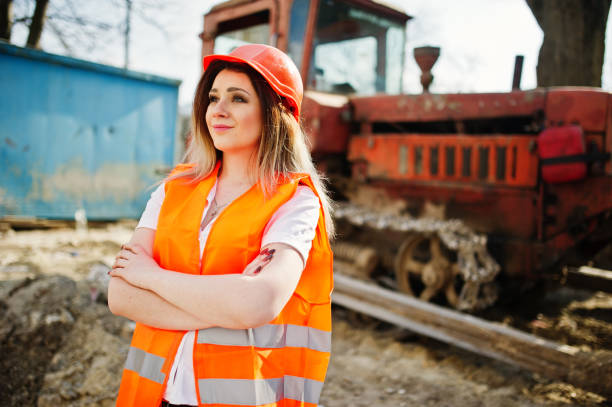 istock Engineer builder woman in uniform waistcoat and orange protective helmet 665630394