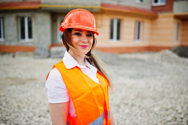 istock Engineer builder woman in uniform waistcoat and orange protective helmet 665630468