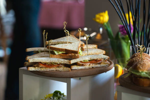 istock Fresh club sandwiches triangular form with tomato on a round wooden chopping board on a table in a expencive restaurant 665630472
