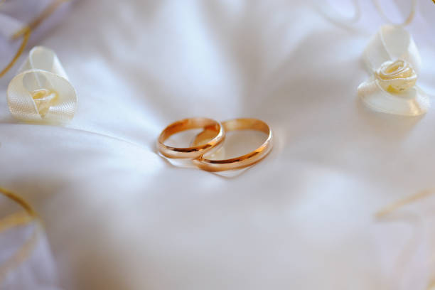 istock Pair of gold wedding rings on a white pillow 665630640
