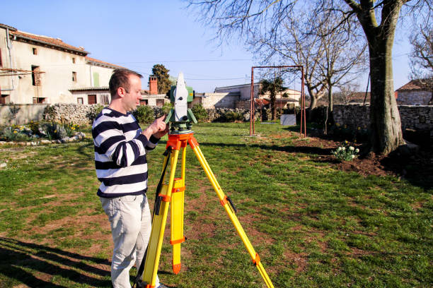 istock Man using of total station. Guy surveyor at work. Survey Instrument geodetic device, total station set in the field. Surveyor worker making measurement in the garden. 665630940