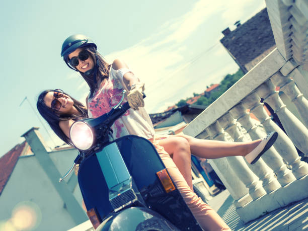 istock Happy girls riding scooter 665631388
