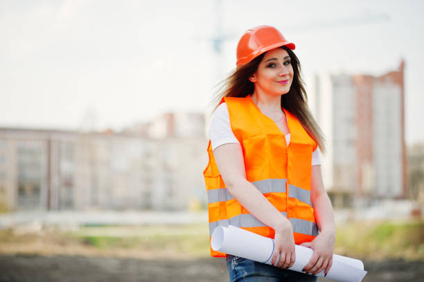 istock Engineer builder woman in uniform waistcoat and orange protective helmet 665636968