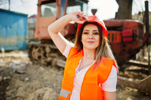 istock Engineer builder woman in uniform waistcoat and orange protective helmet 665637058
