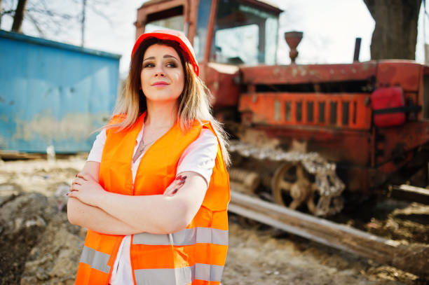 istock Engineer builder woman in uniform waistcoat and orange protective helmet 665637080