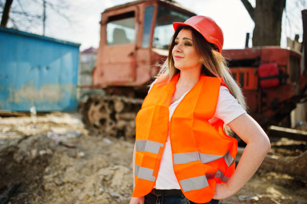 istock Engineer builder woman in uniform waistcoat and orange protective helmet 665637142