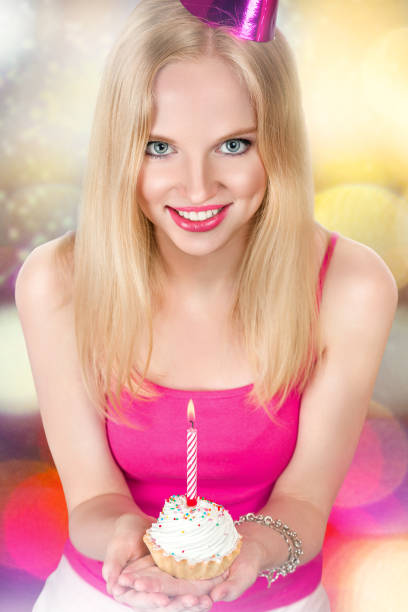 istock Young woman with birthday cupcake 665637200