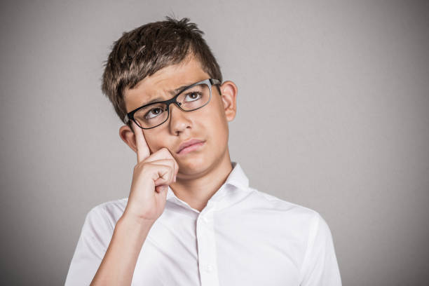 istock young man daydreaming looking up, finger on temple gesture 665637786