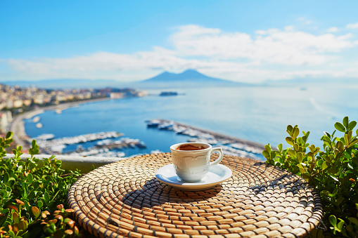 Cup of fresh espresso coffee in a cafe with view on Vesuvius mount in Naples, Campania, Southern Italy