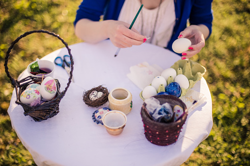 Close-up of woman decorating easter eggs for holiday with decoupage technique