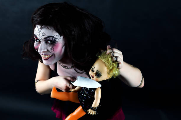 Model In Stage Makeup Doll Head Cut Off With Knife Stock Photo