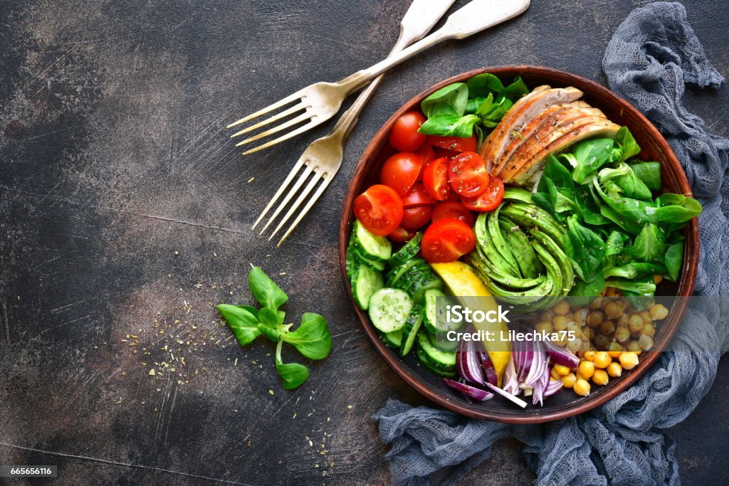Lunch bowl with vegetables,beans and chicken meat Lunch bowl with vegetables,beans and chicken meat on a dark slate,stone or metal background.Top view. Springtime Stock Photo