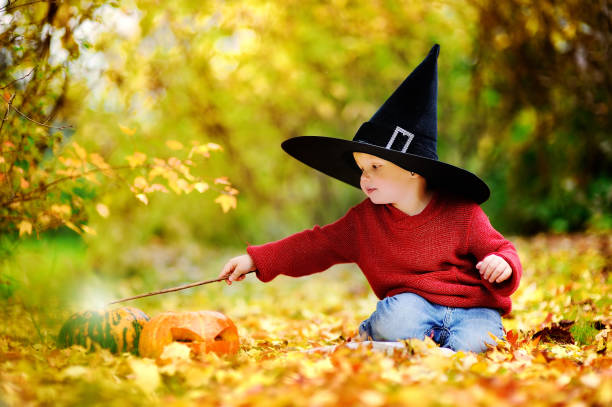малыш мальчик в остроконечной шляпе, играя с волшебной палочкой на открытом воздухе - 5084 стоковые фото и изображения