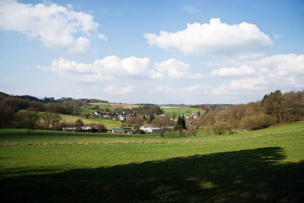 istock Meadow landscape with village under blue sky with clouds 665656978