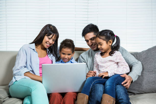 istock Smiling family on the sofa using laptop 665666320