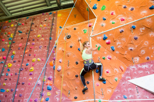 istock Fit blonde rock climbing indoors 665666352