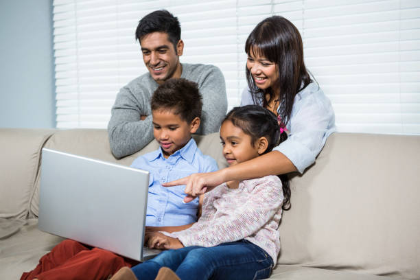 istock Smiling family using laptop on the sofa 665666486