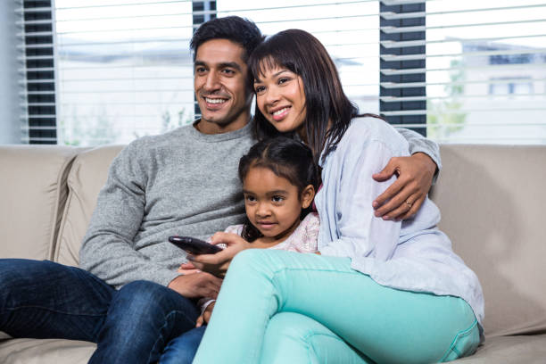 Smiling family on the sofa watching tv